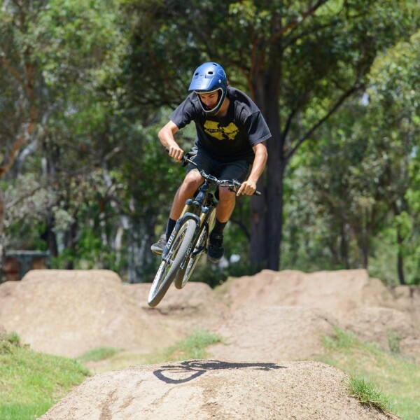 BMX rider doing a stunt and flyer over dirt hill